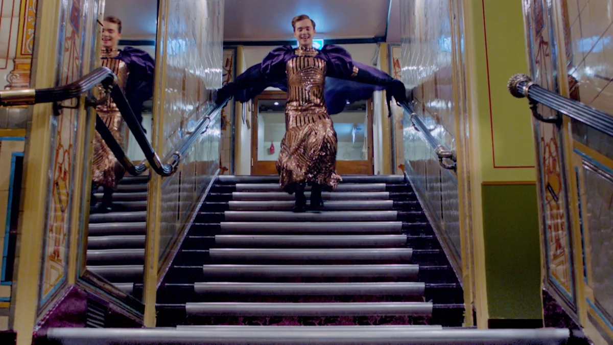A figure leaps down a staircase within a lavish interior.