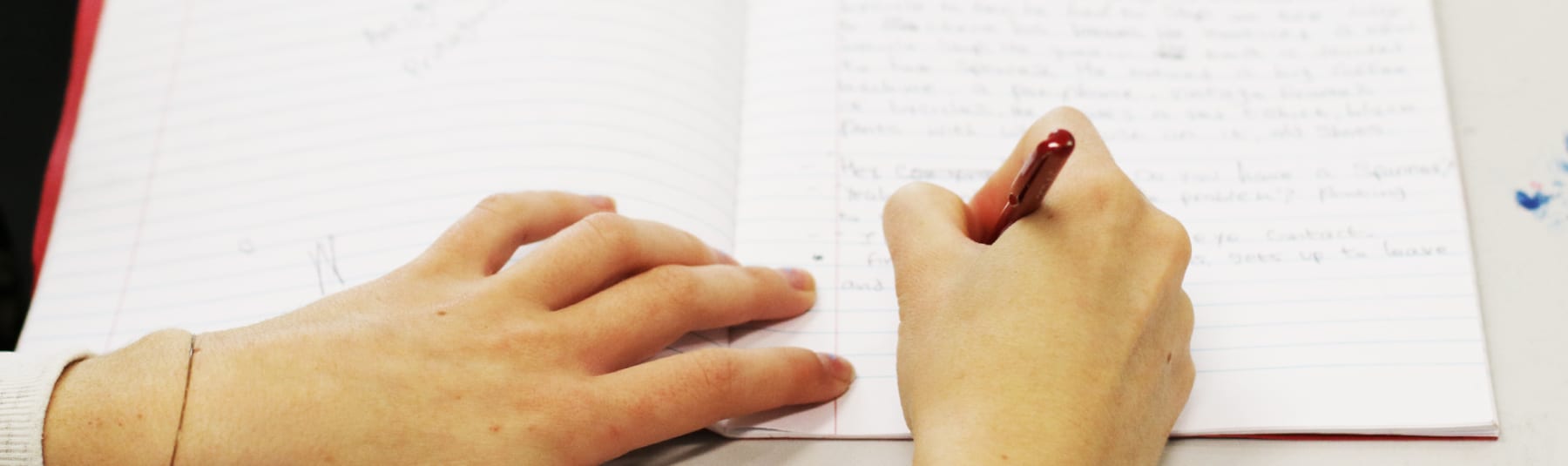 Student writing in notebook.