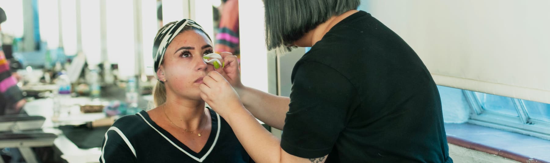 Student applying make up to another student