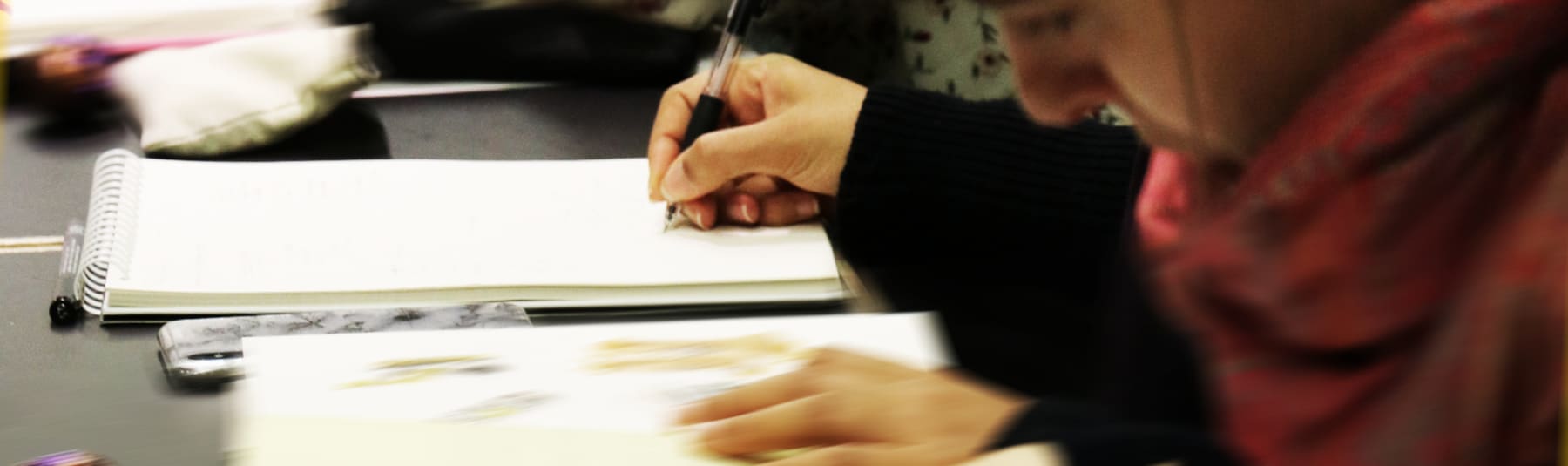 Student writing in notepad