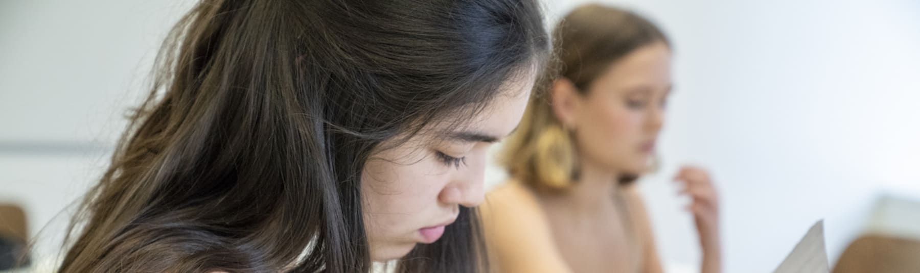 Student cutting out work in classroom