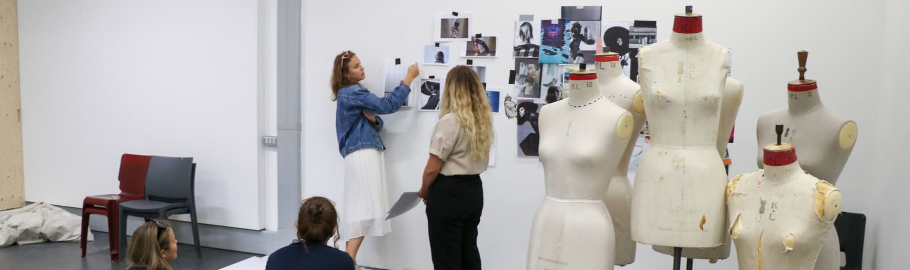 Students looking at photographs stuff to a wall