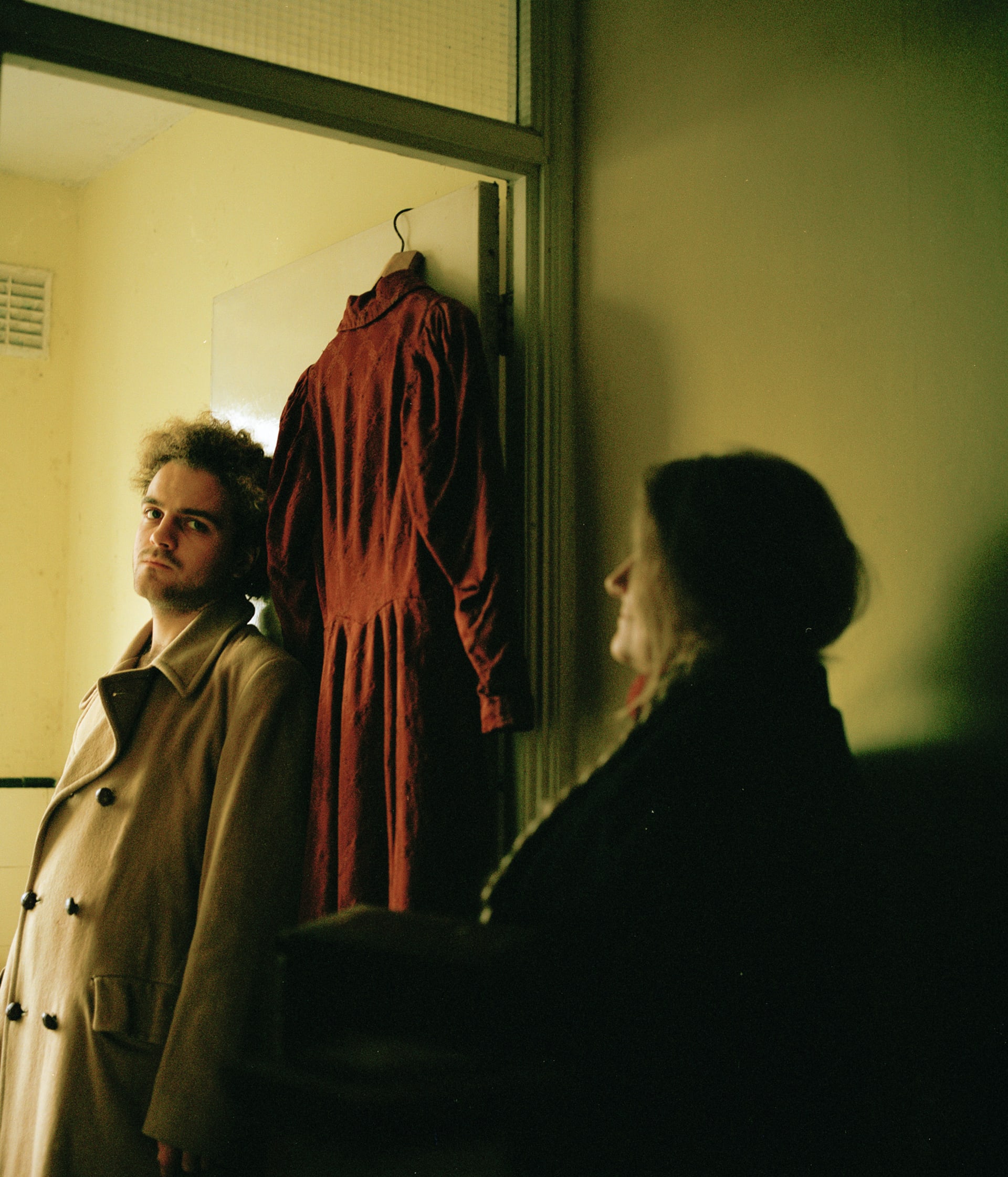 Mother and son, framed by doorway, staring in opposite directions