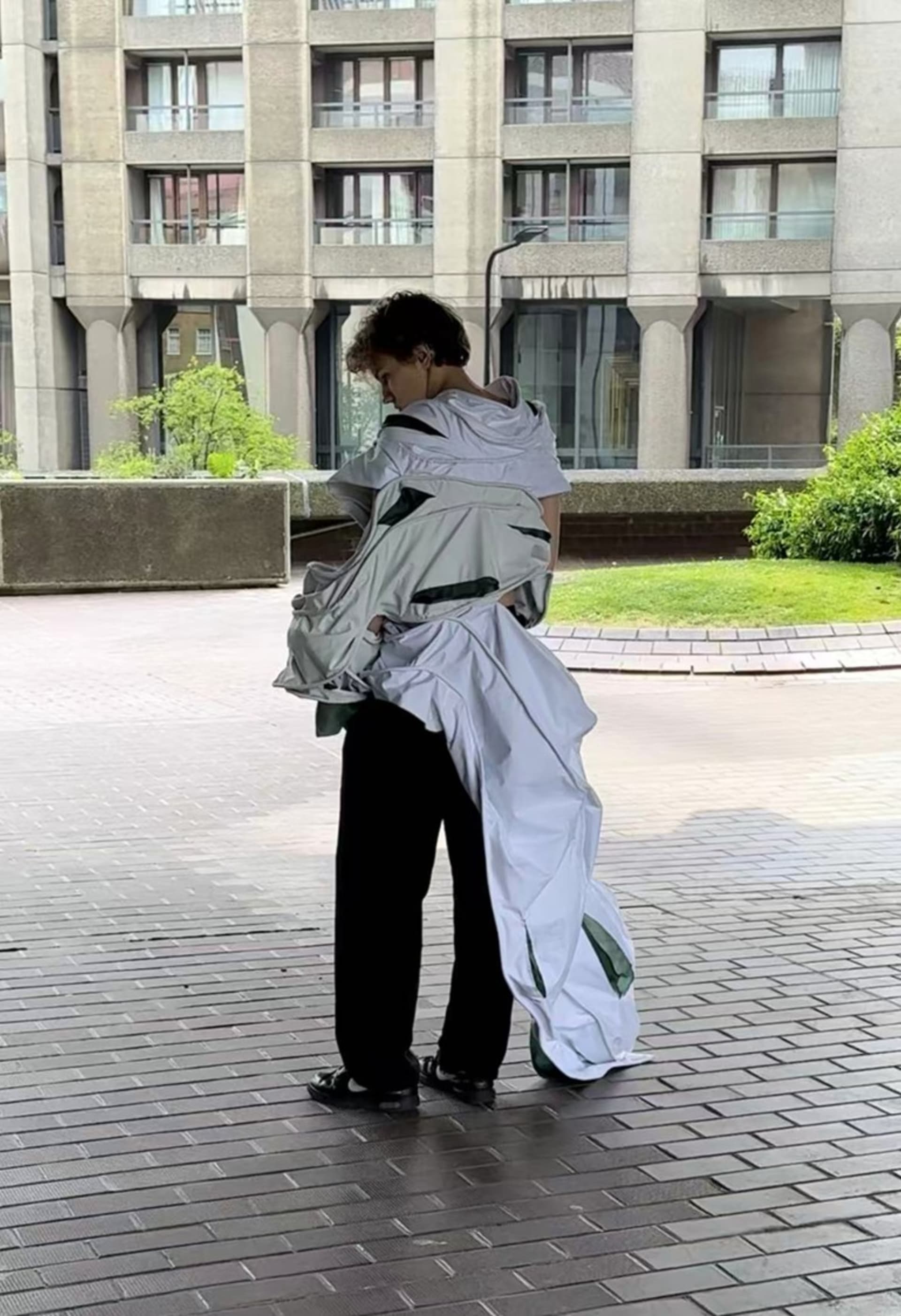 Man with his back facing in pleated wired pocketed garment