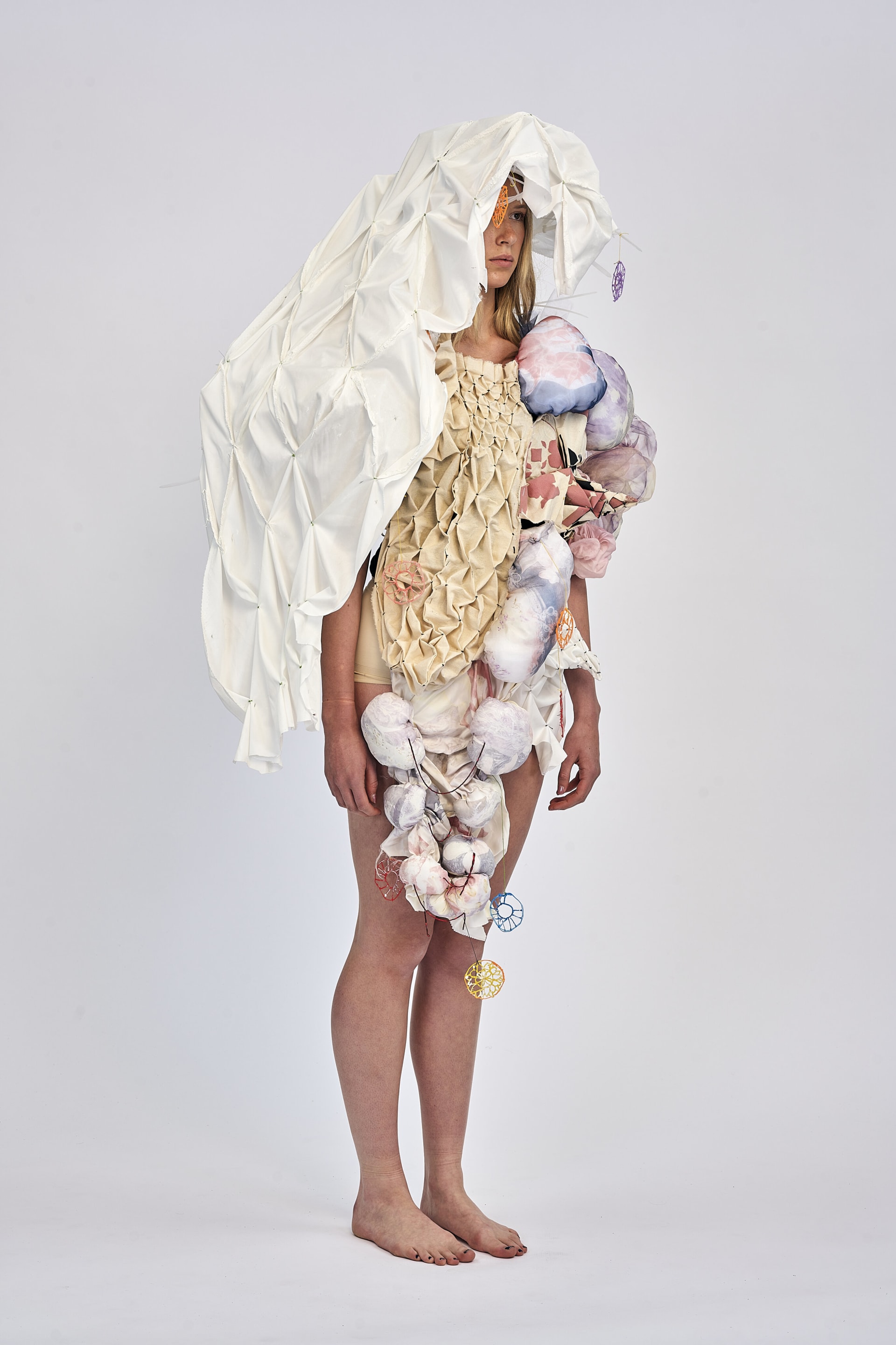 right side profile showing final garments a textiles collection of honey comb smocking, heat fabric manipulation, resist printing, radial smocking.