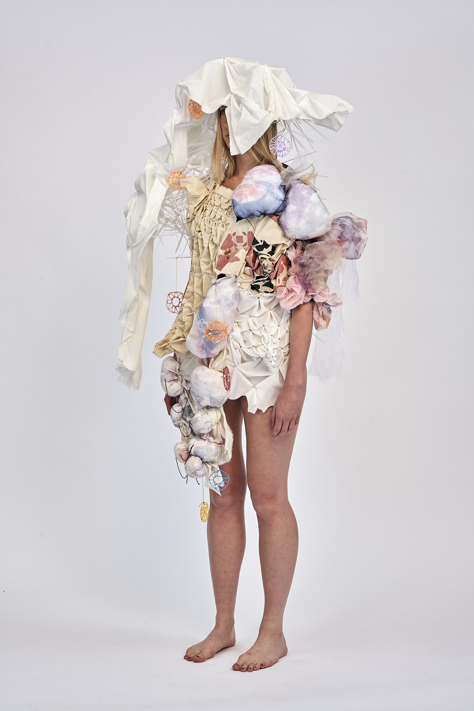 left side profile showing final garments a textiles collection of honey comb smocking, heat fabric manipulation, resist printing, radial smocking.