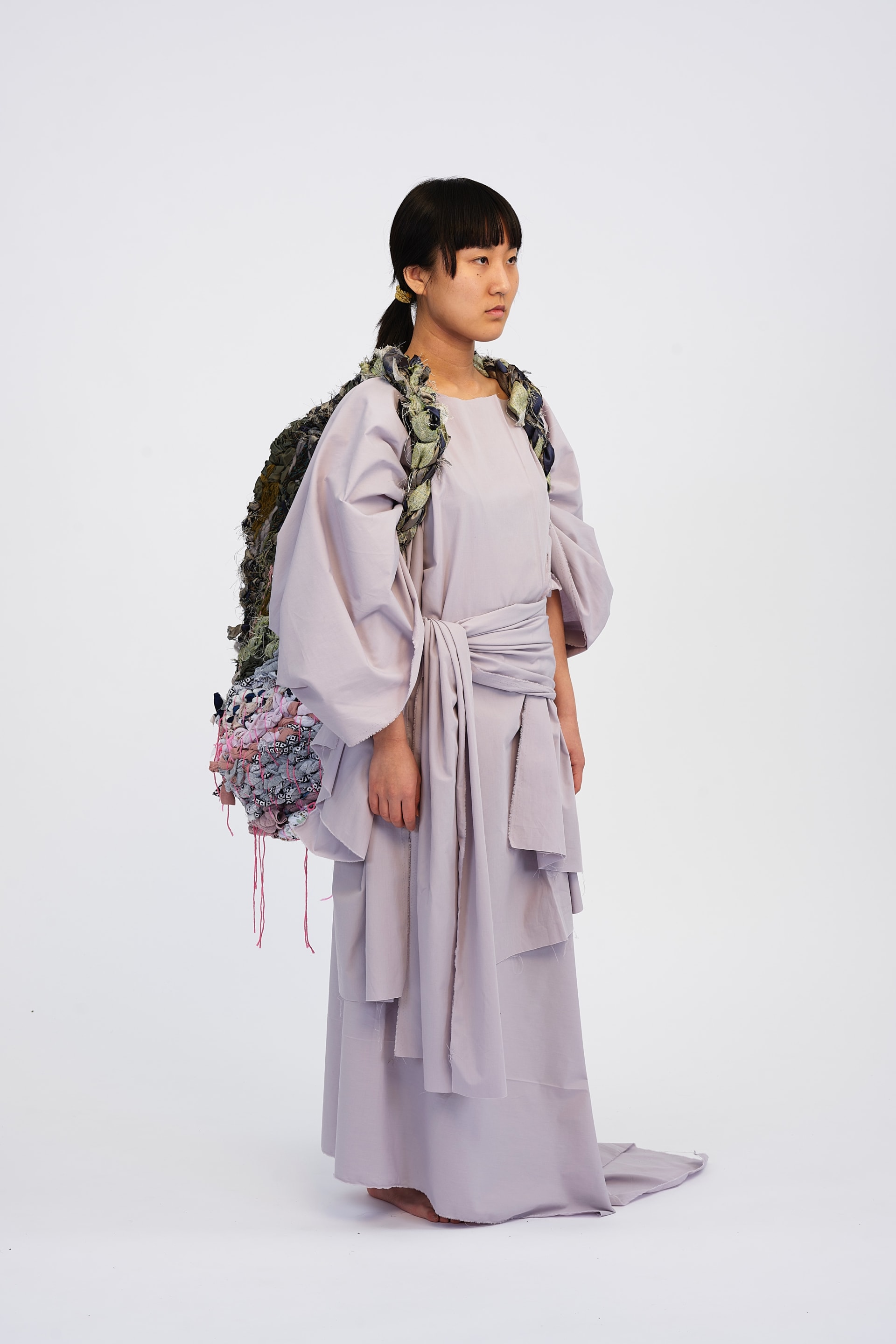 A forward facing angle displaying more of the draped garment, showing the flowing layers to it.