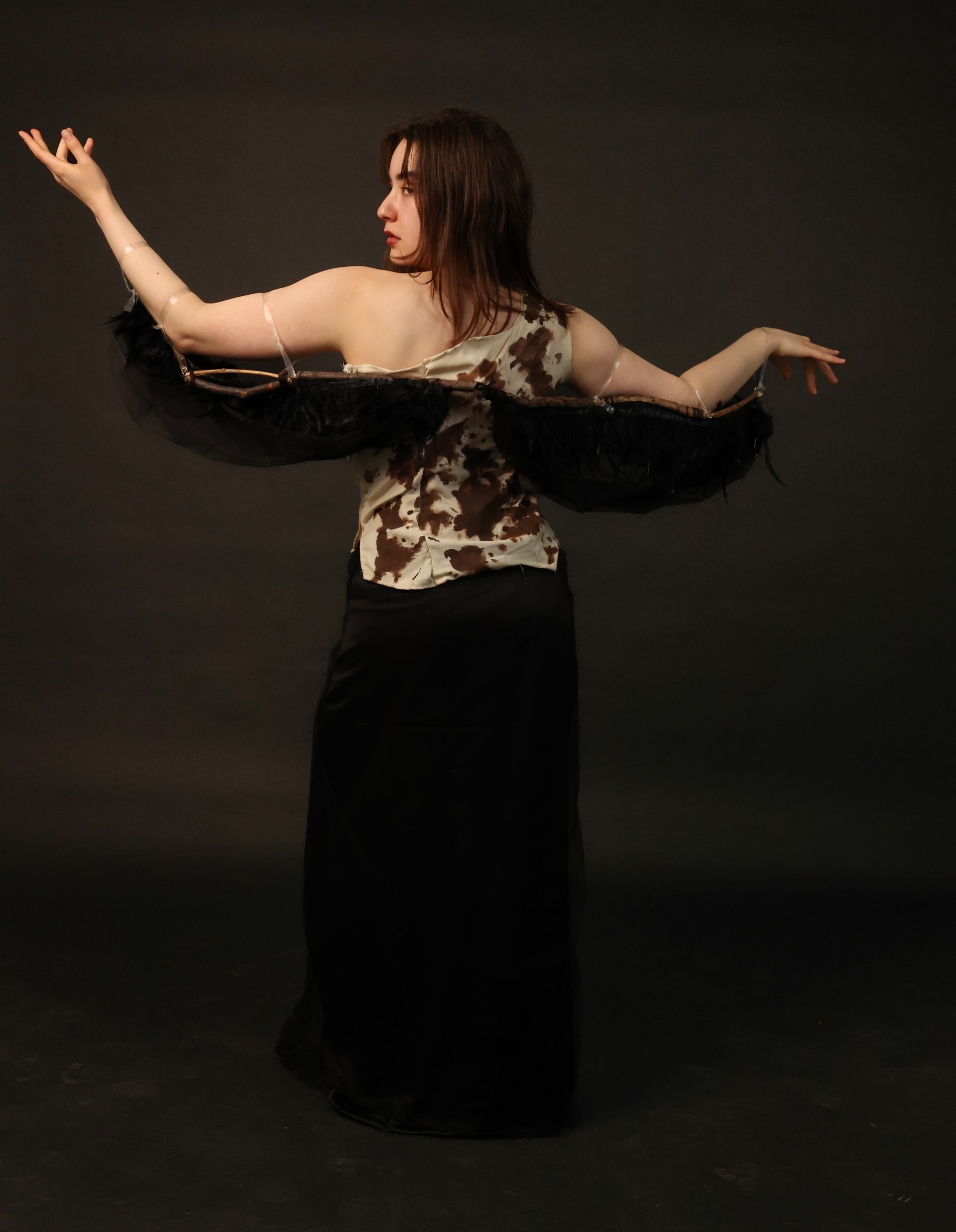 The back view of a woman wearing a costume that resembles a bird hatching out of an egg.