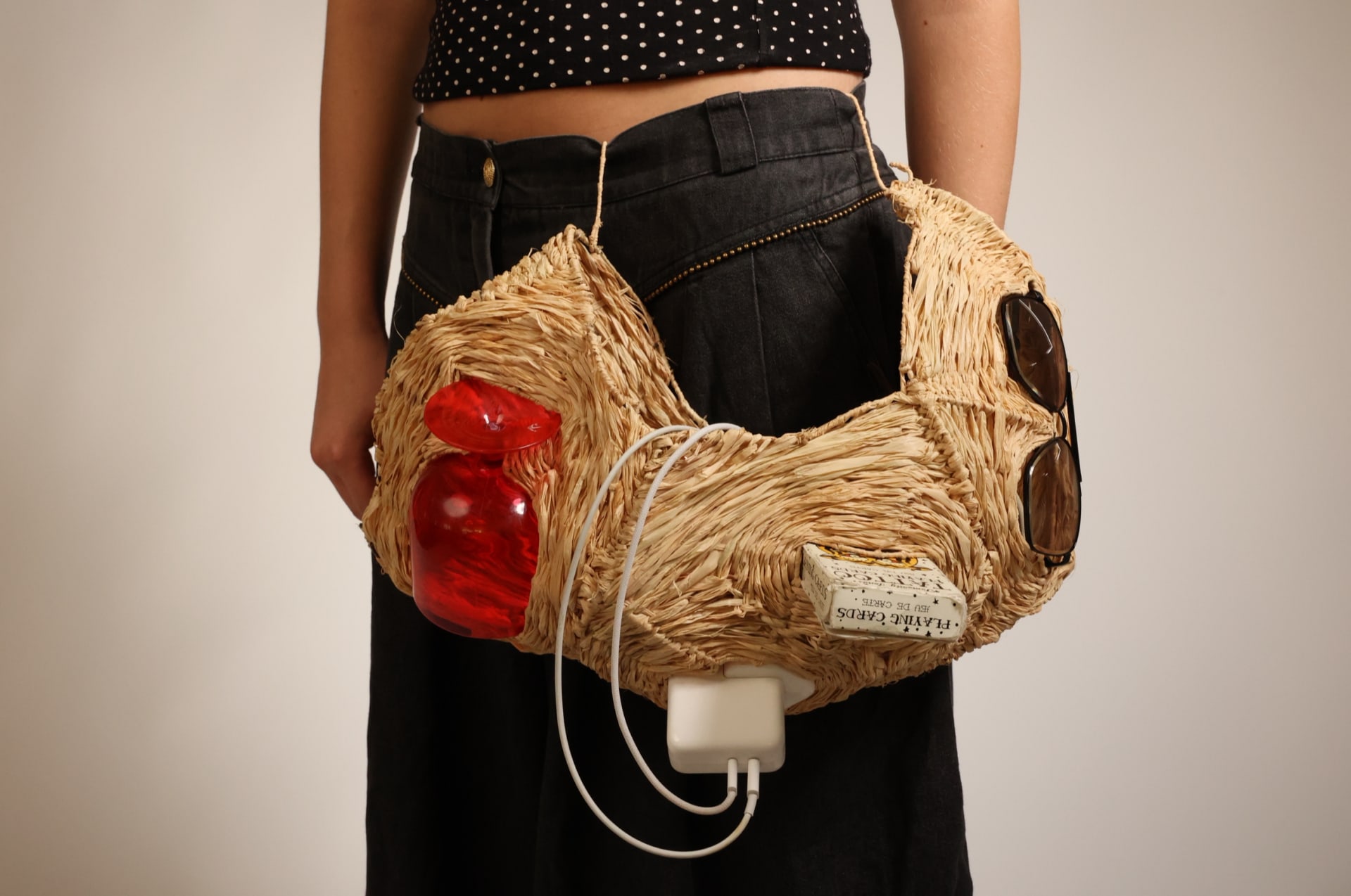 Raffia hip bag holding displaced objects 