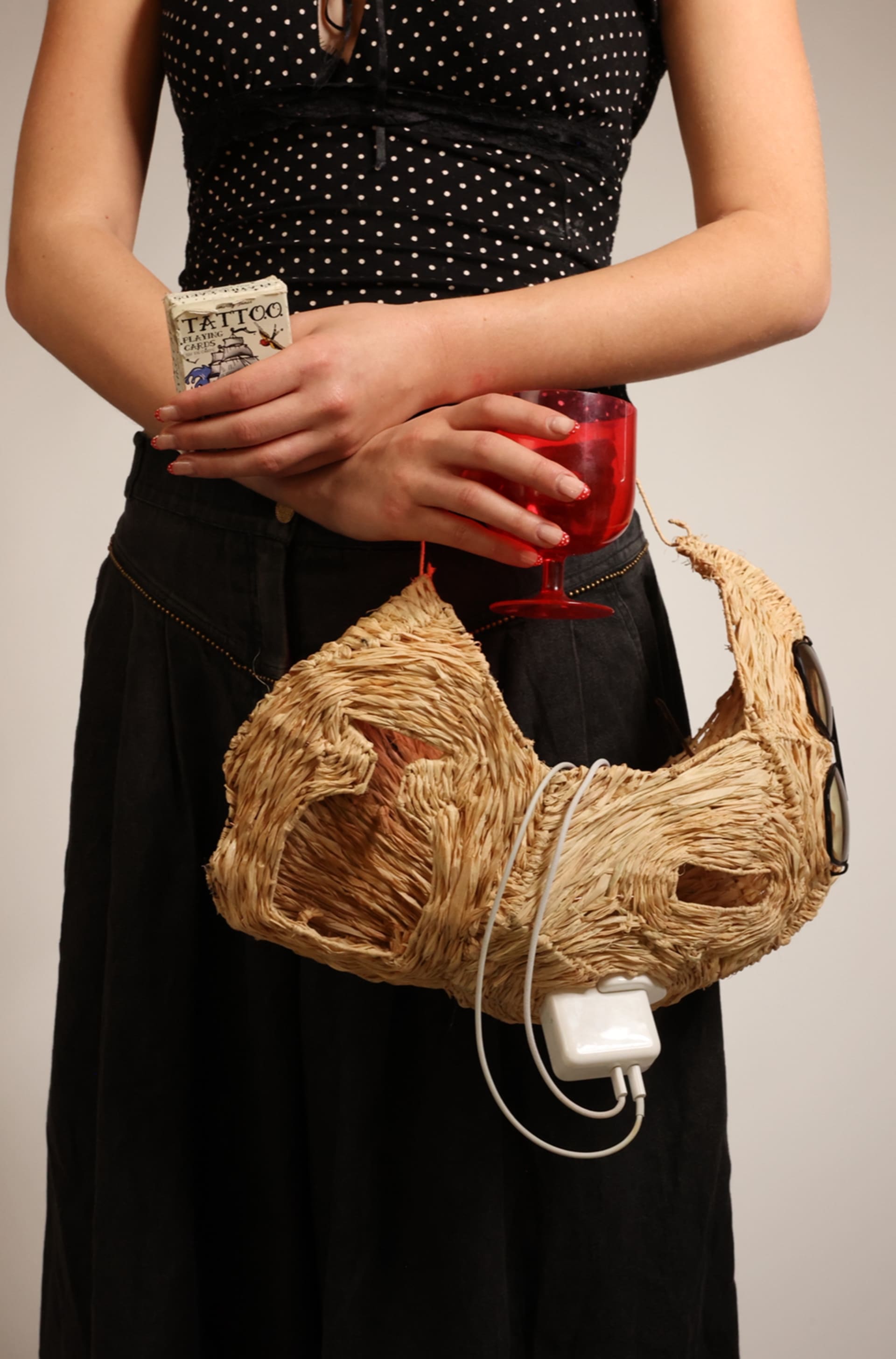 Raffia hip bag holding displaced objects 