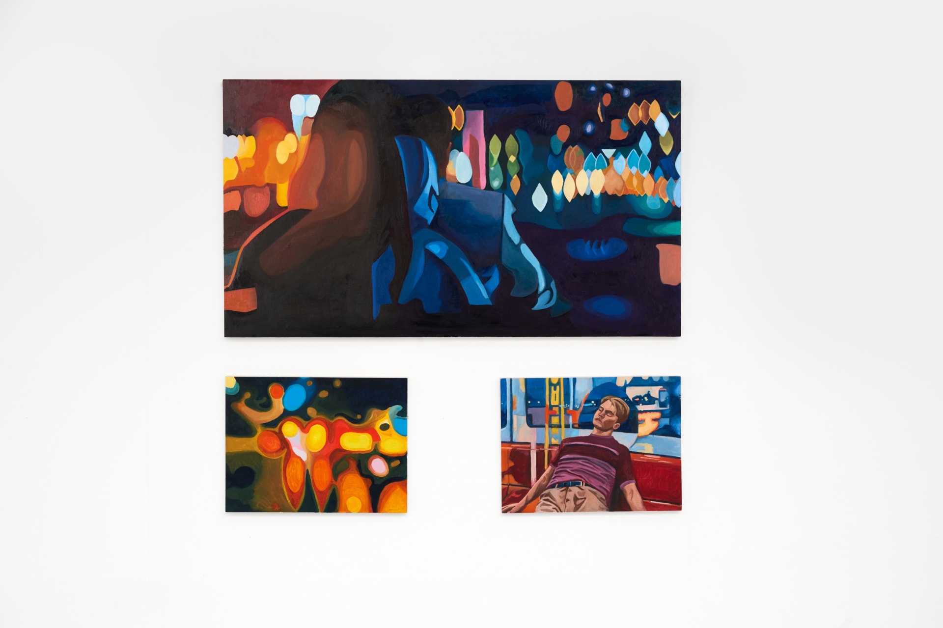 Three paintings on a white wall: a man and a woman in a car at night, an abstract light scene, and a man reclining on a train bench.