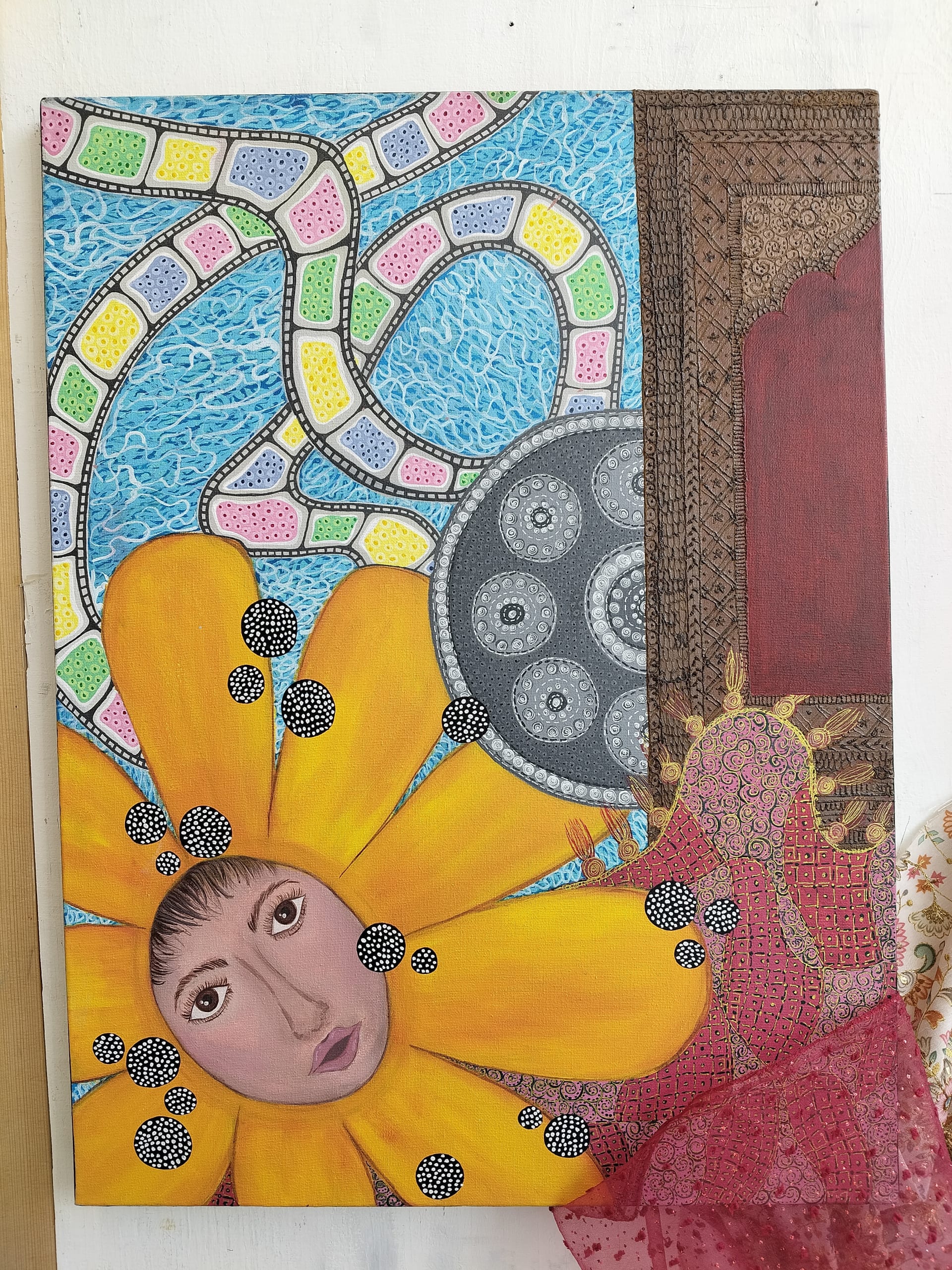 A face emerges from a bright yellow flower against a background of pastel mosaic paths, swirling blue water, detailed brown arches, and dotted circles