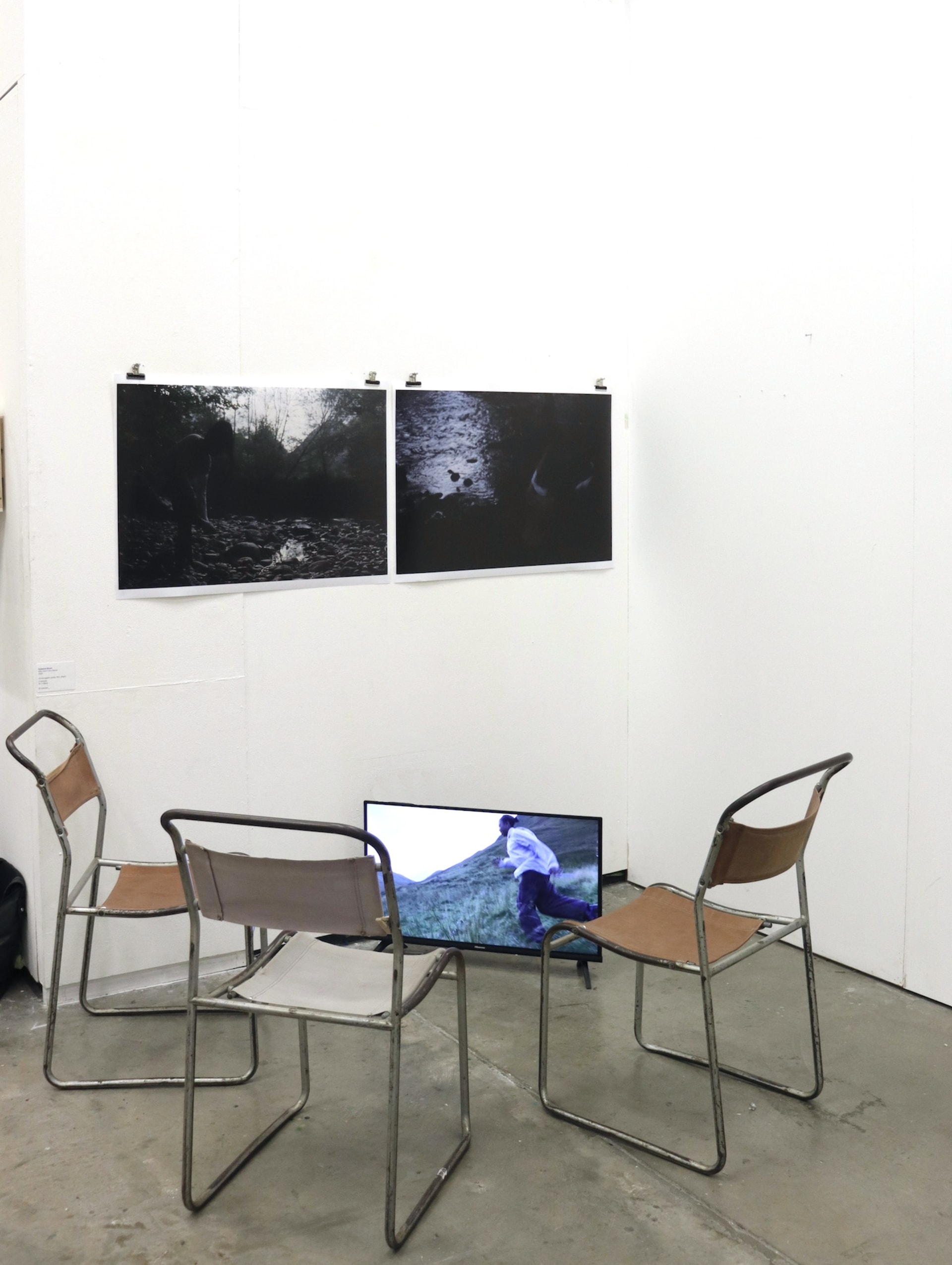 3 chairs in a circle, TV monitor on the floor, prints on the wall.