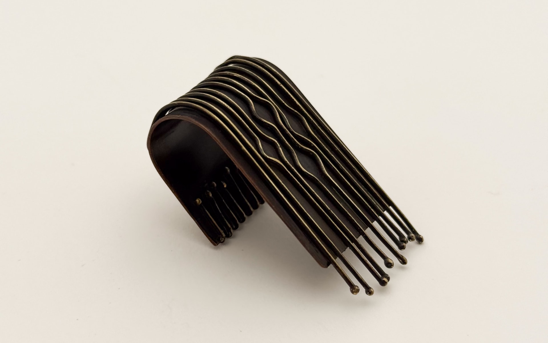 dark brown patinated ring with wire bending technique resembling traditional Indonesian textile