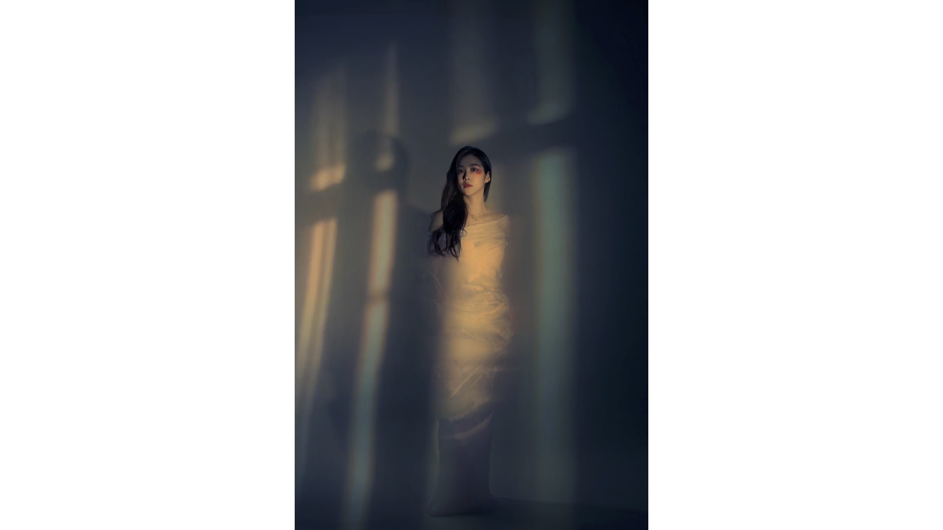 A standing woman wrapped in cotton fibres, frozen in stillness—capturing a quiet moment of hesitation before transformation begins.