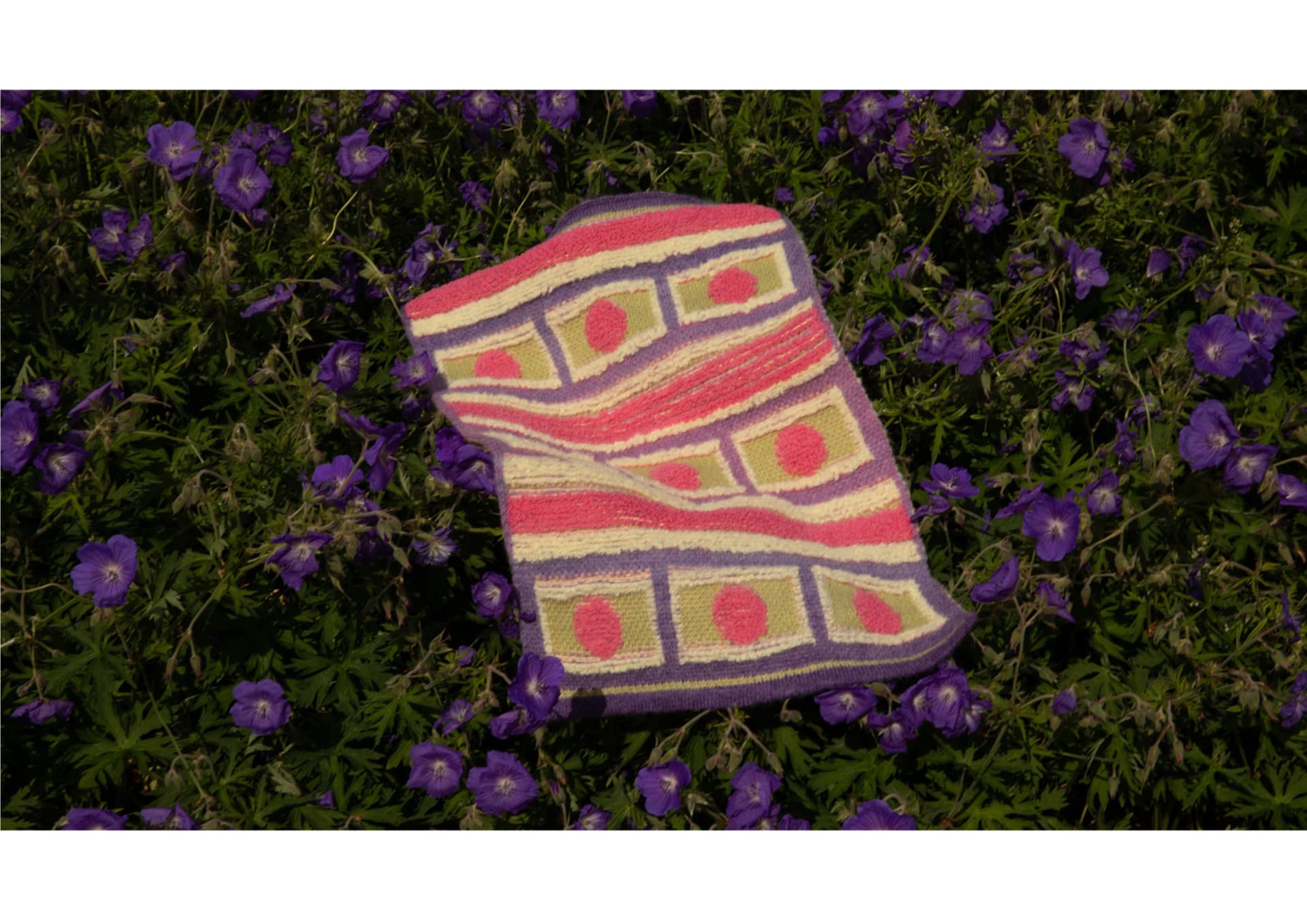 Stoll jacquard terry knitting composed of patterns in green, purple, pink, and yellow, with partial terry loop technique.
