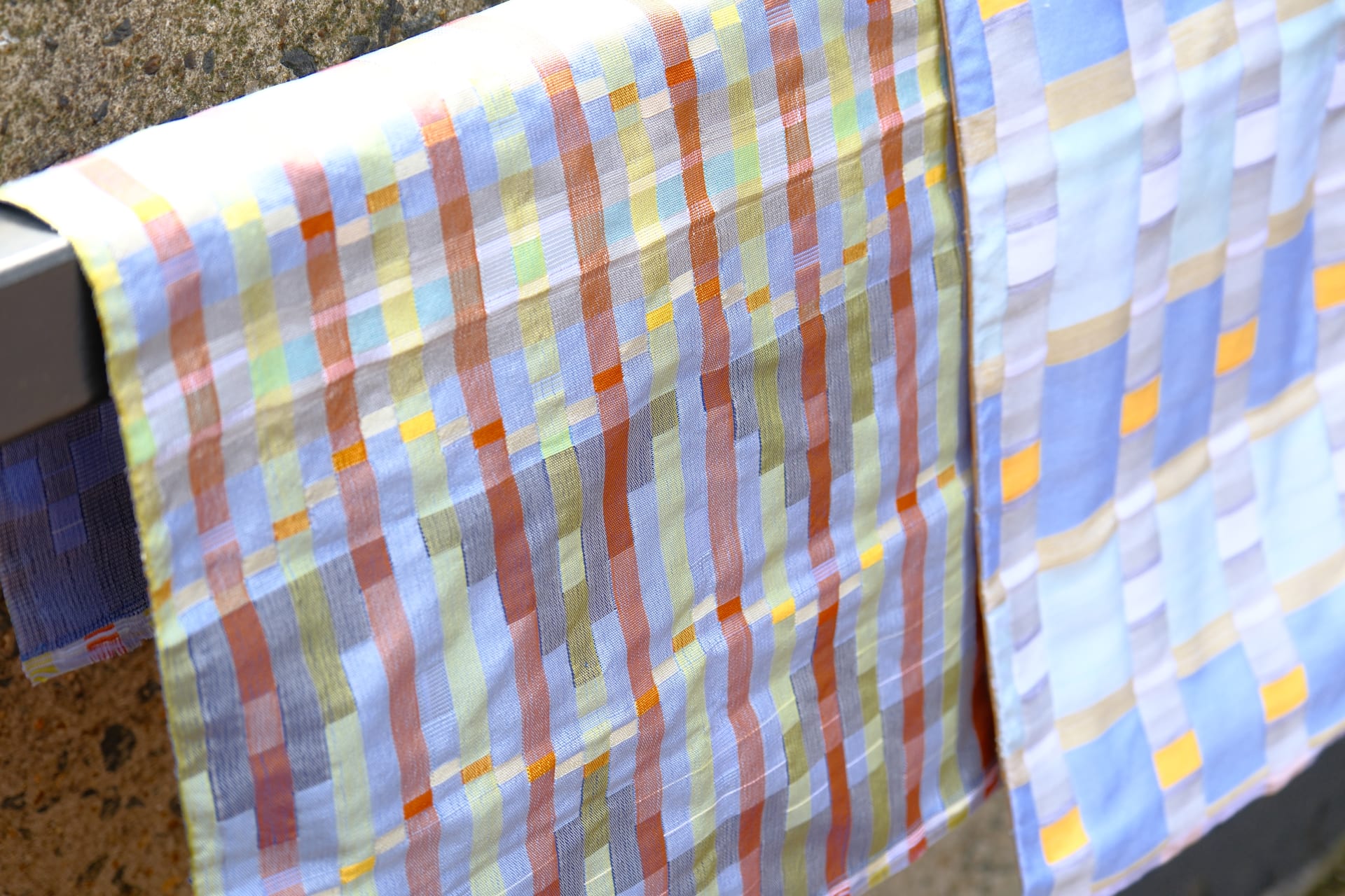 A piece of fabric contains red, blue and yellow stripes forming waves.