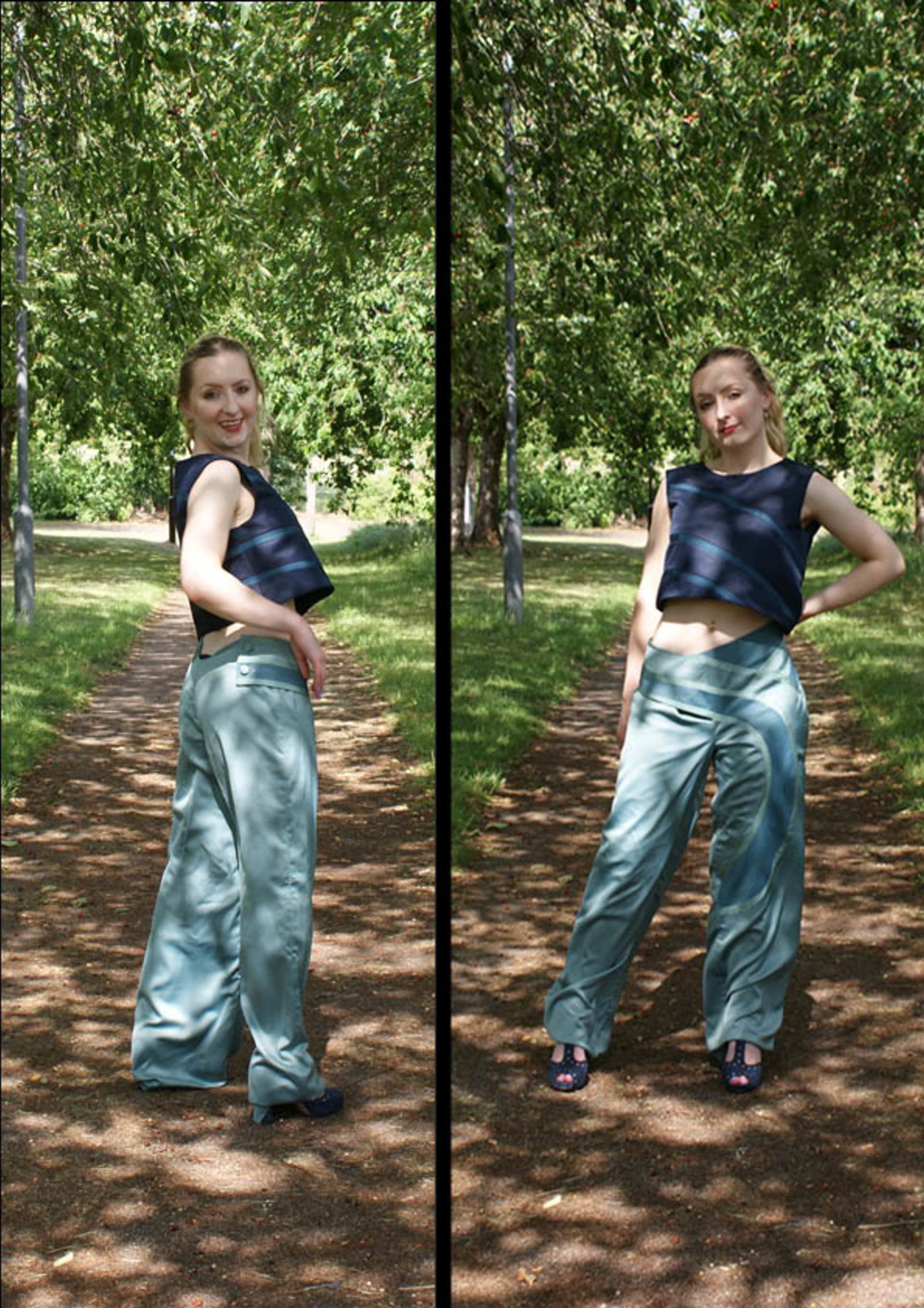 Blue top with three pieces of ribbon running across the body. Asymmetrical green trousers with ribbons running on the right side of the body