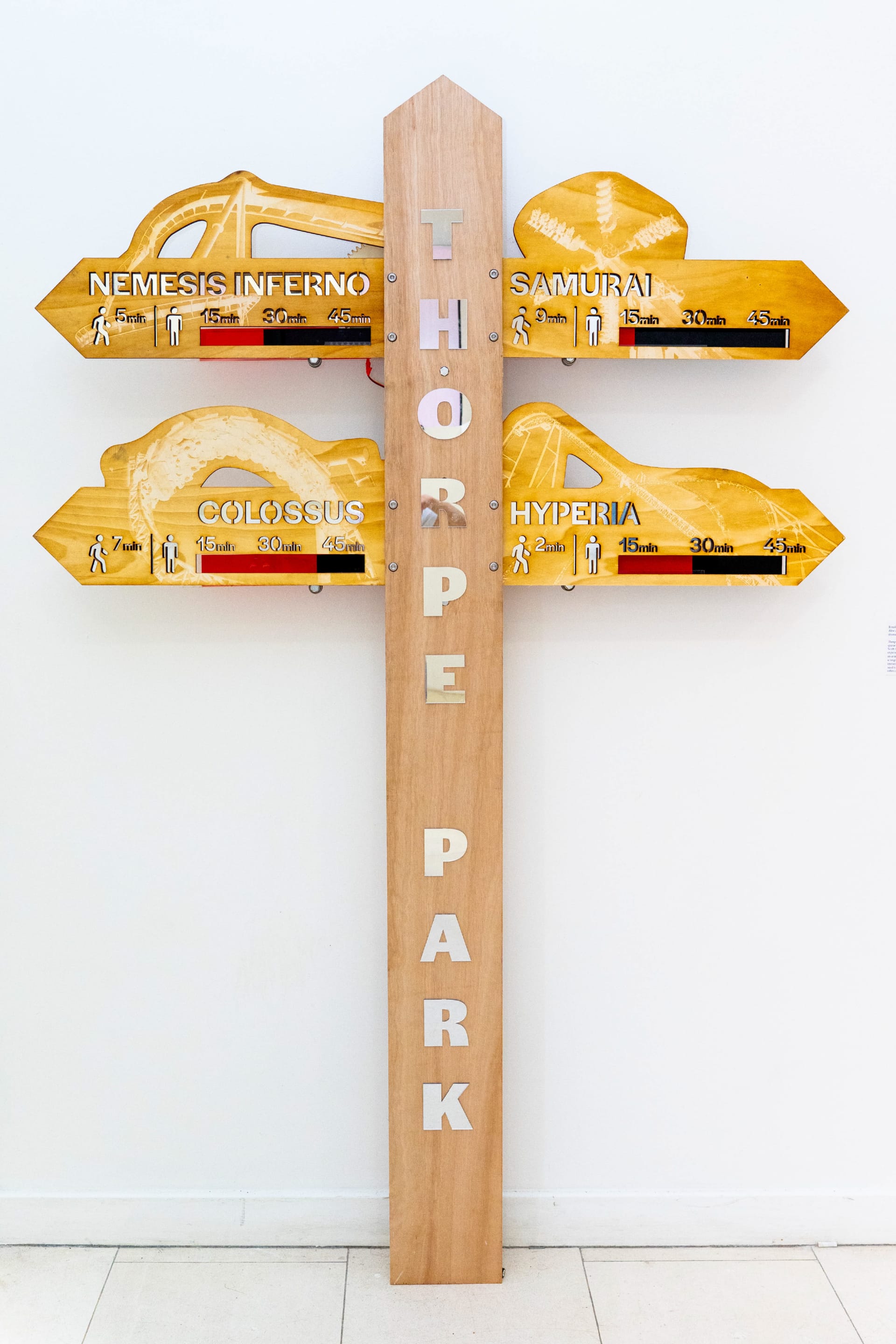 Wooden sign showing walk times and queue times for popular rides at Thorpe park.