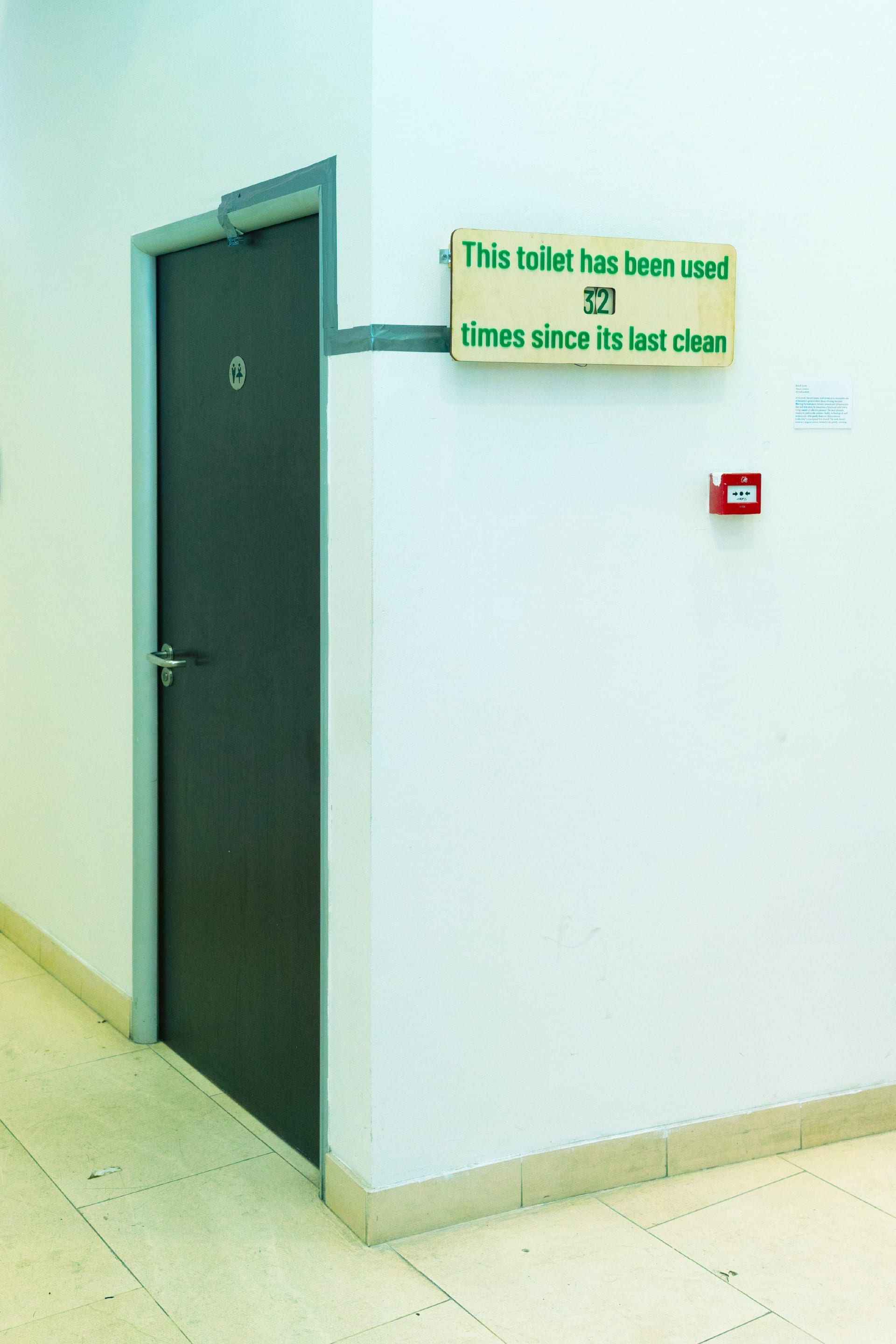 A toilet door with a sing near by reading "this toilet has been used x times"