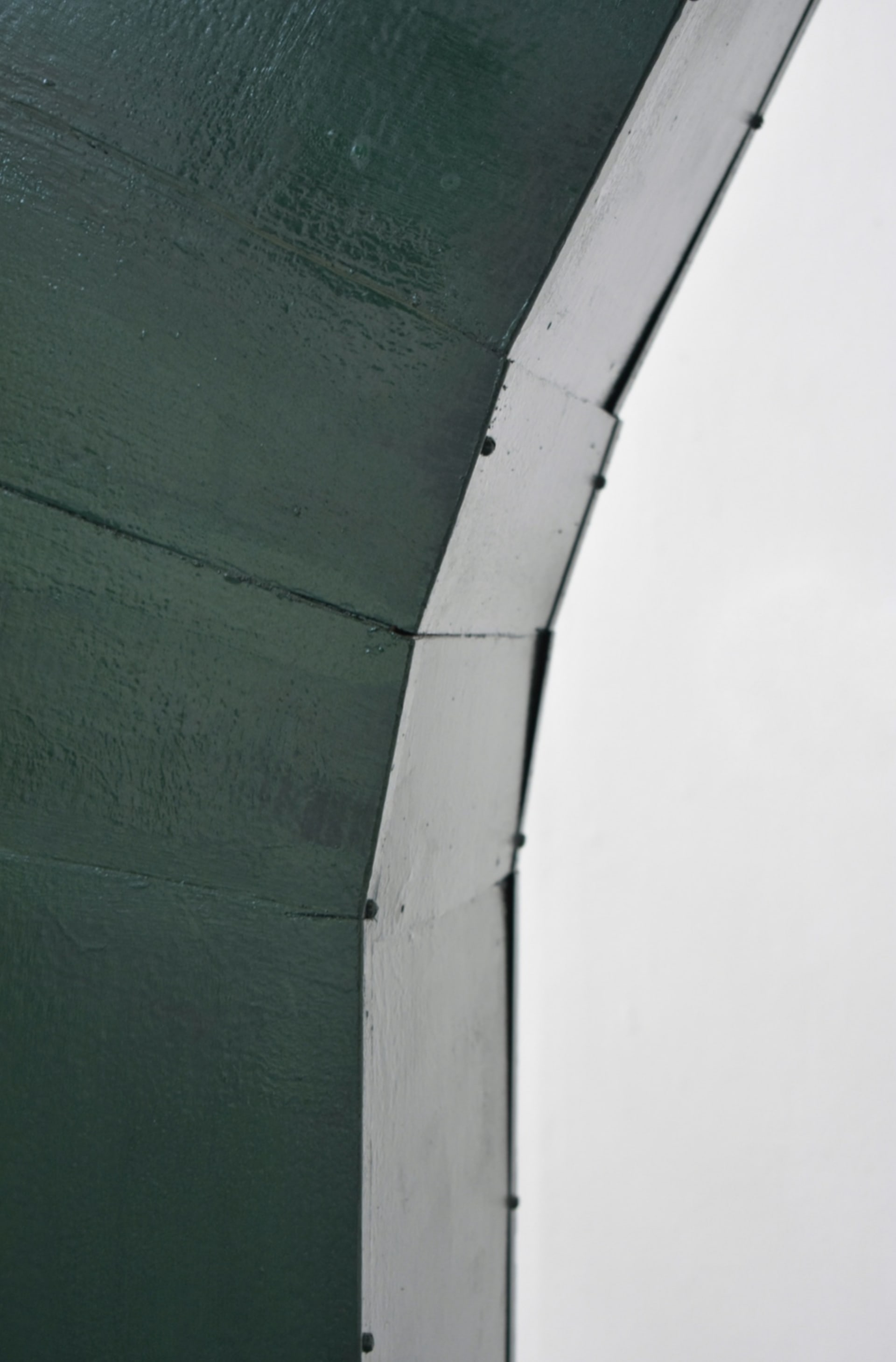 Close up of green painted metal locker, cut to bend.