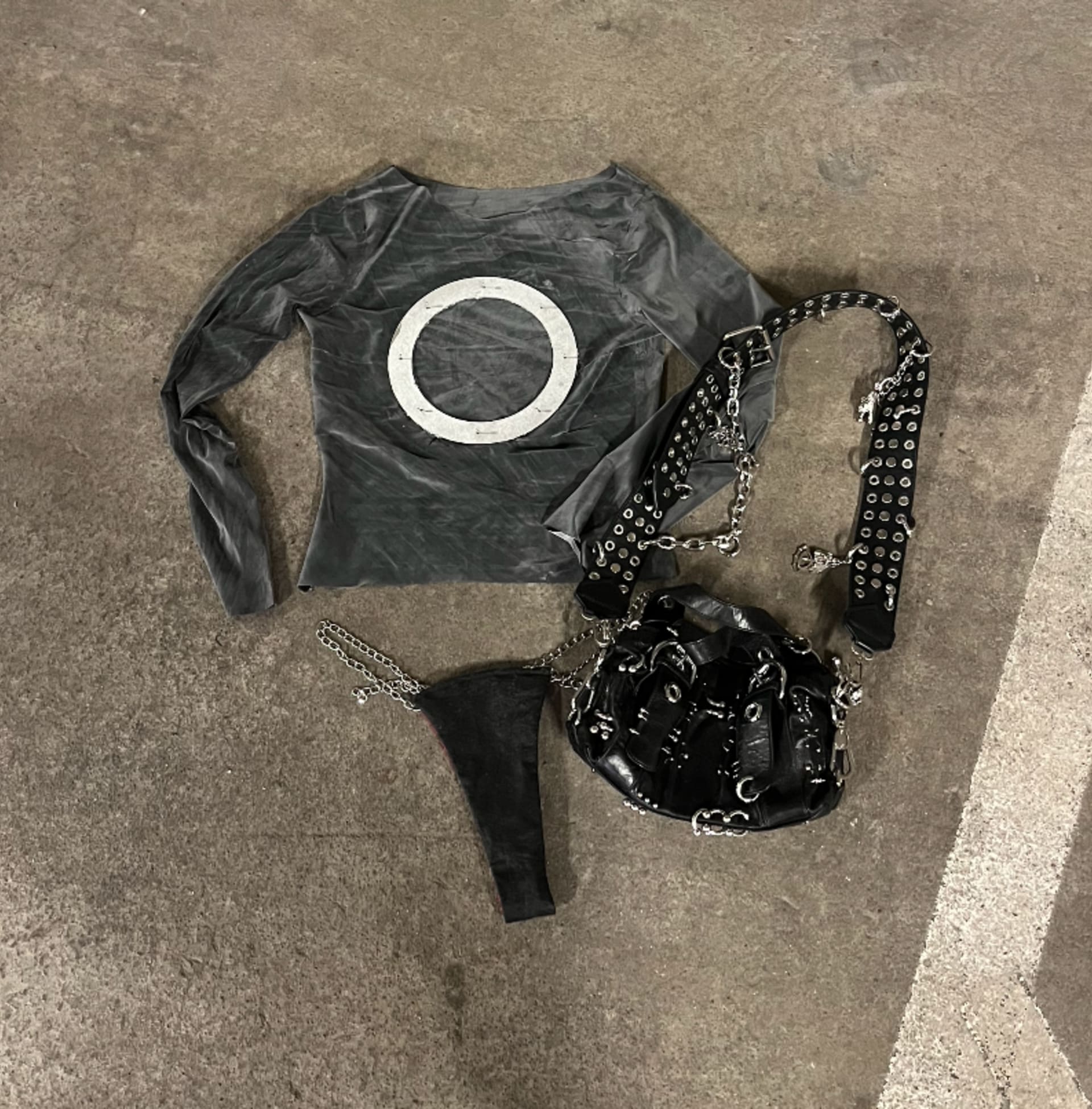 Latex top with metal detail that resembles a stretched piercing