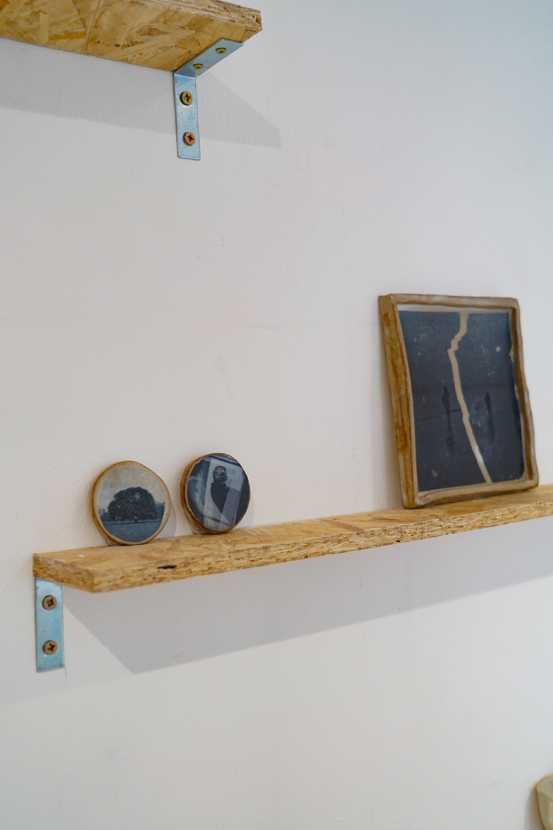 Two circular ceramic pieces with black and white images set onto them