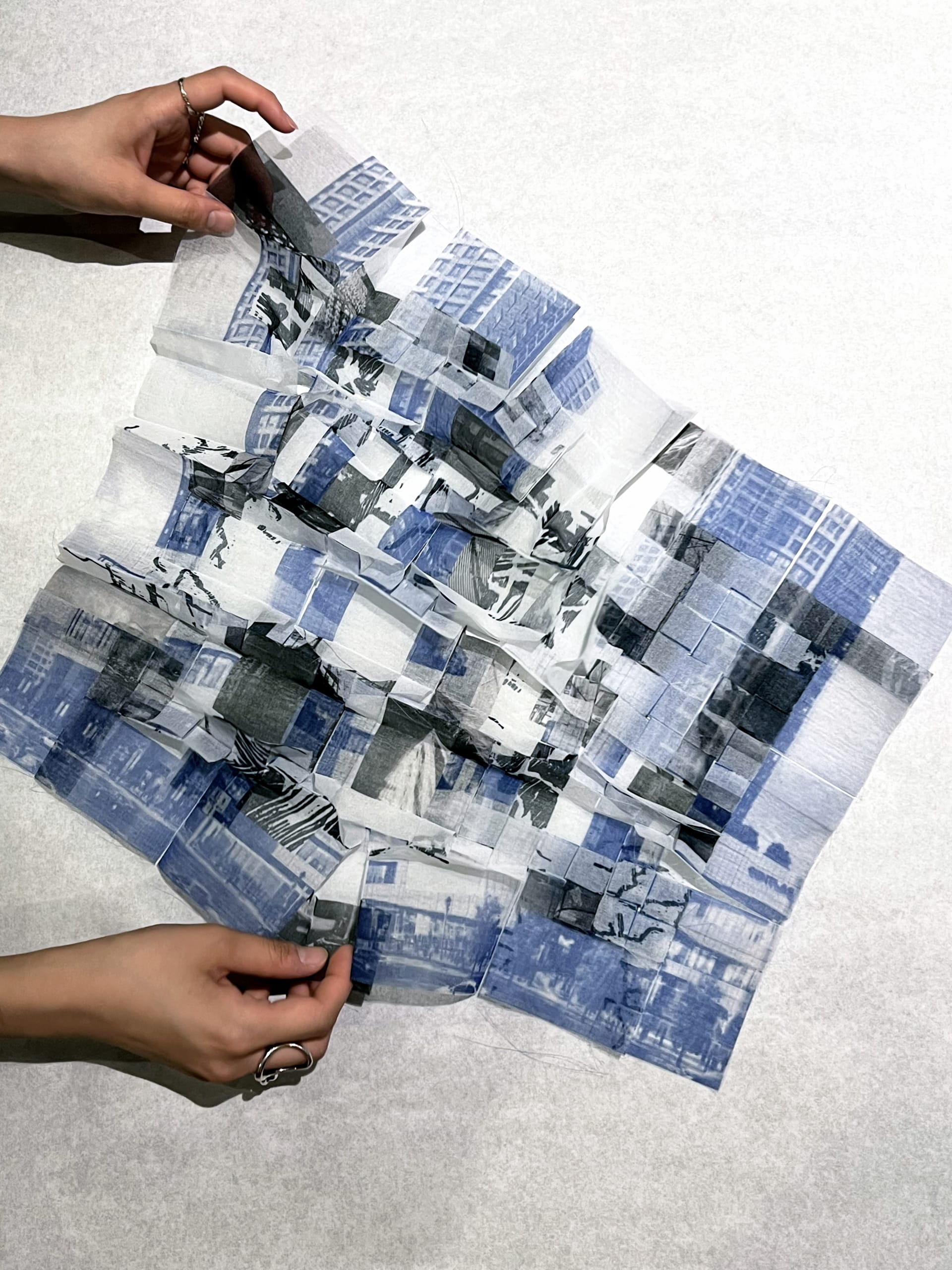 A folded translucent textile layered with urban imagery of the present and past.