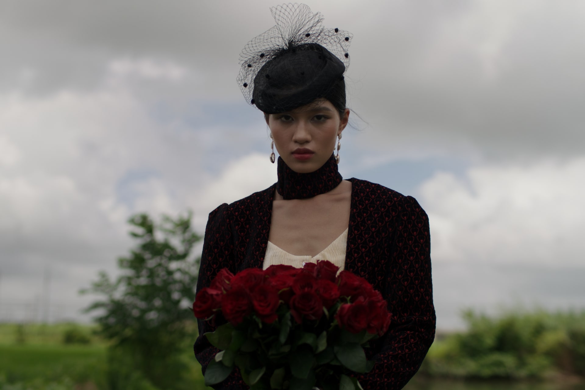 A female holding 33 red roses.
