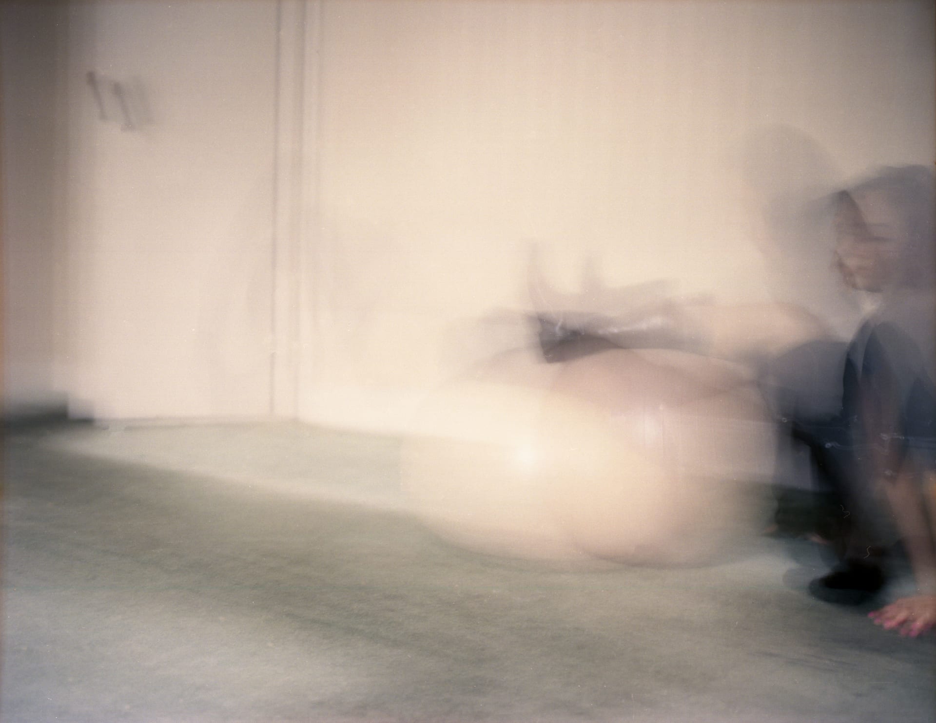 A blurred figure and a large exercise ball overlap, leaving ghost-like motion trails.