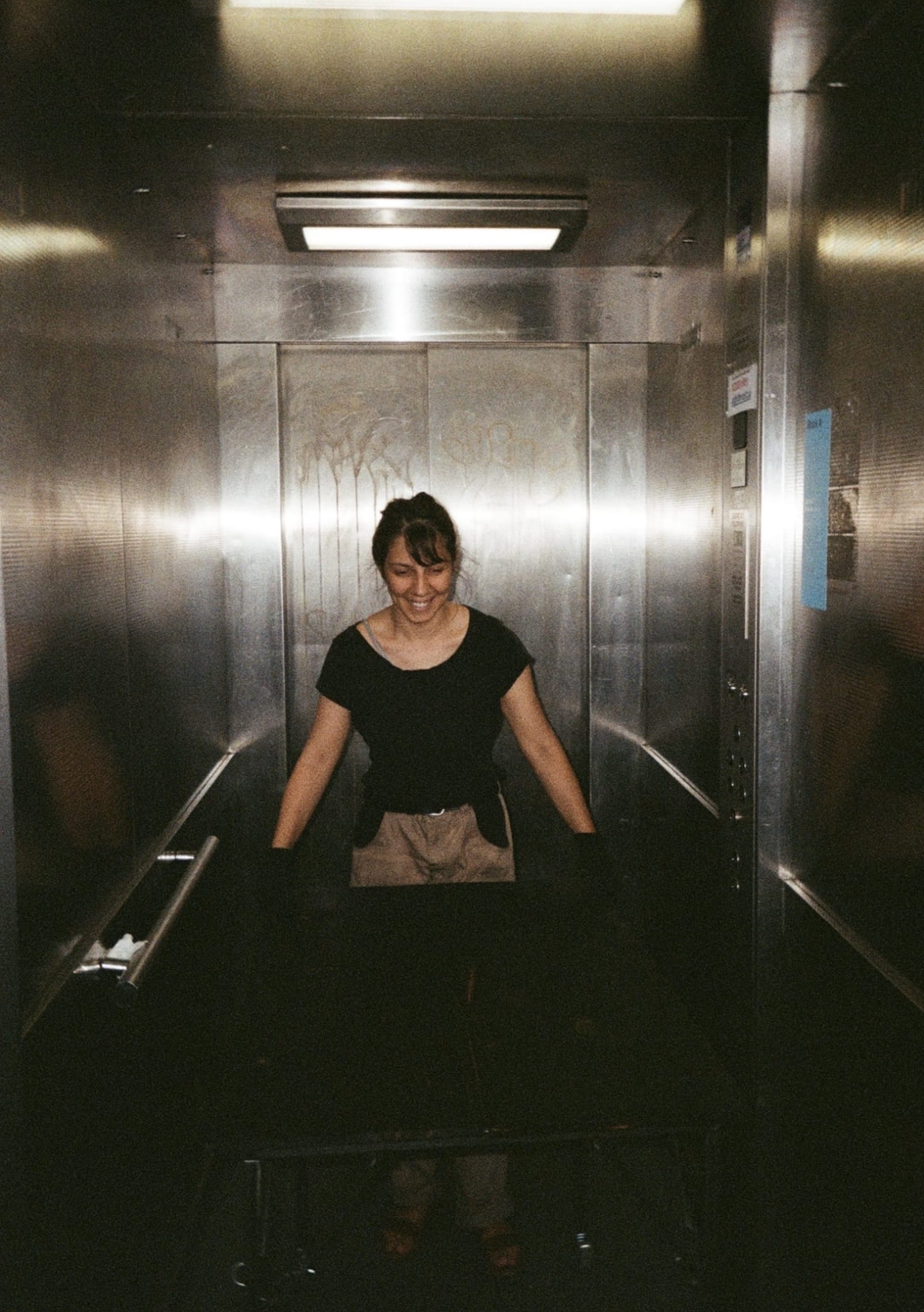 artists handling artwork inside of the lift