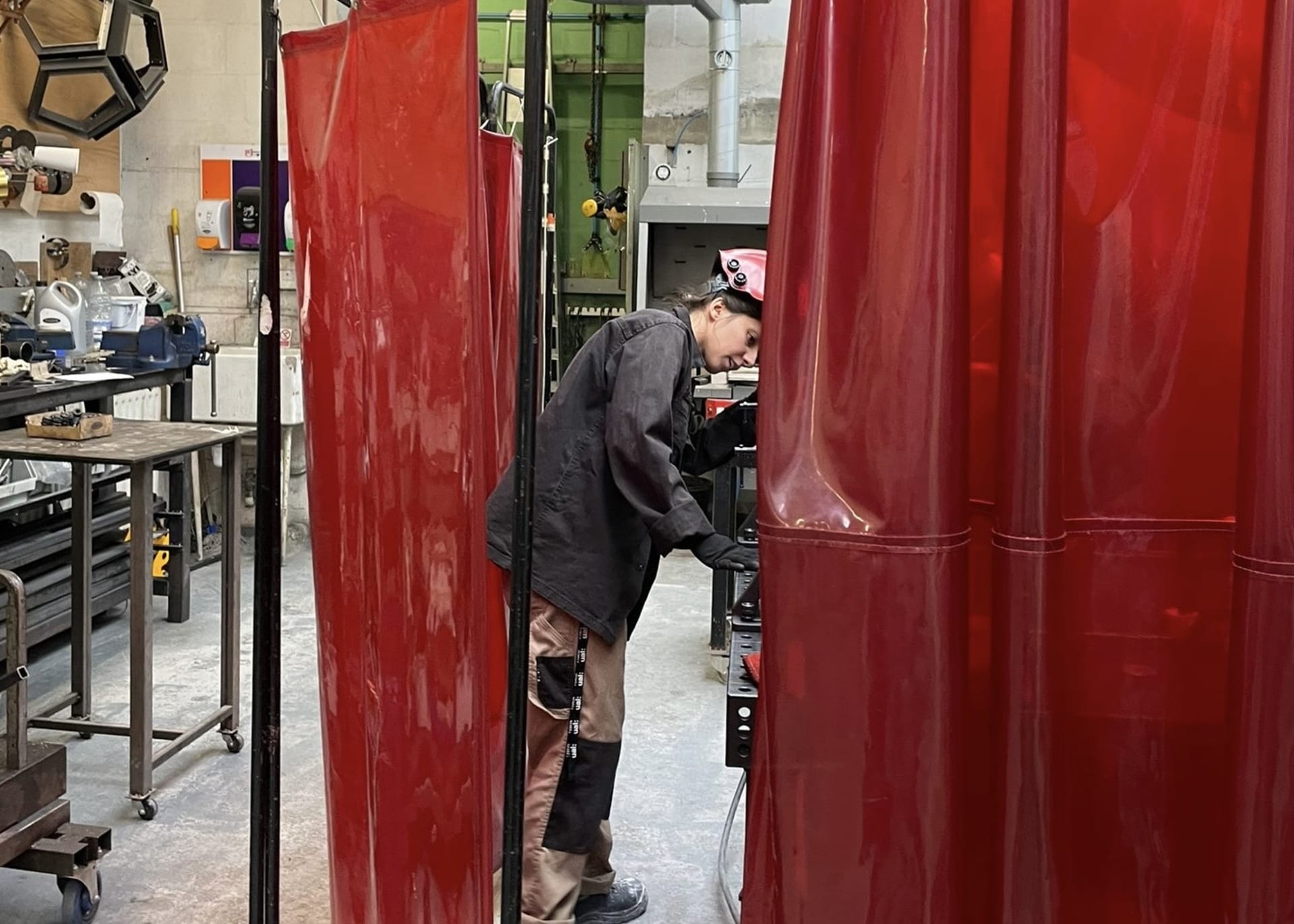 artist in metal workshop welding metal parts to the work 
