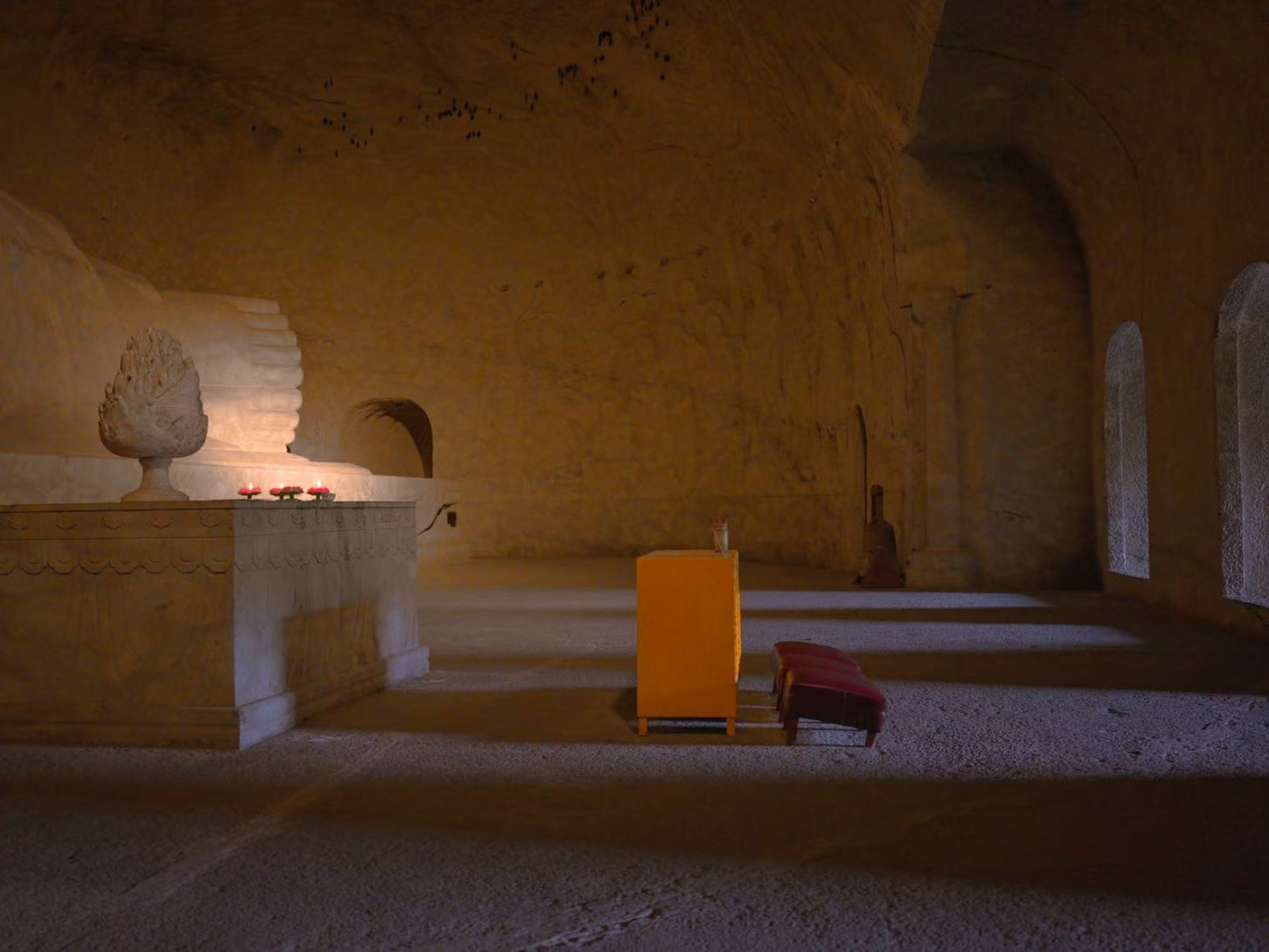 The Buddha statue's feet are visible in one corner of the image. At the center is an offering table for incense and donations. In the distance, high a