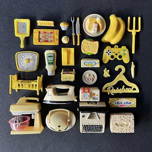  A series of small models of household items, laid out in a square on a dark background. 