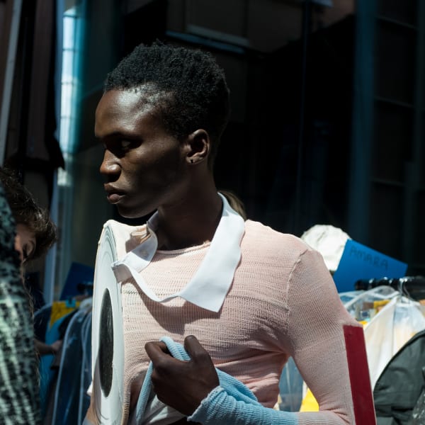 A model wearing a pink and blue knitted top and trousers 