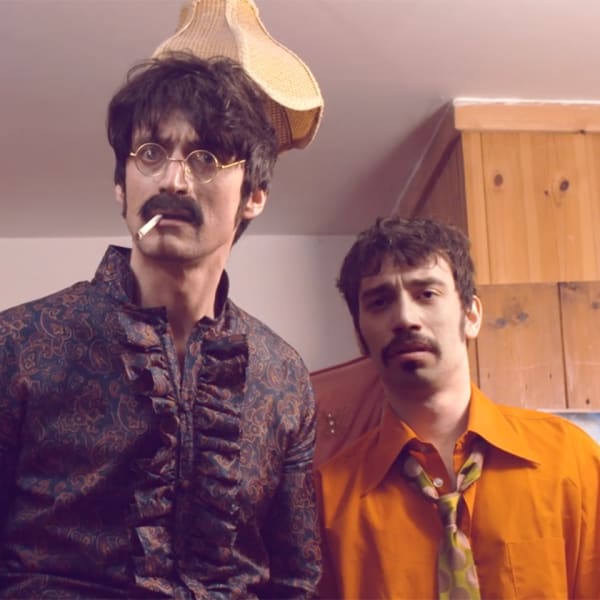 Three men resembling members of The Beatles look at the camera in a confused way.