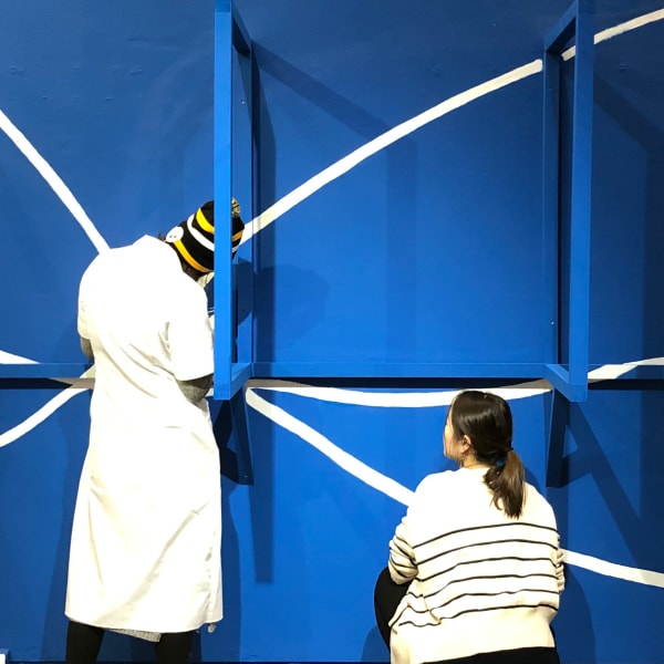 3 students installing an exhibition.
