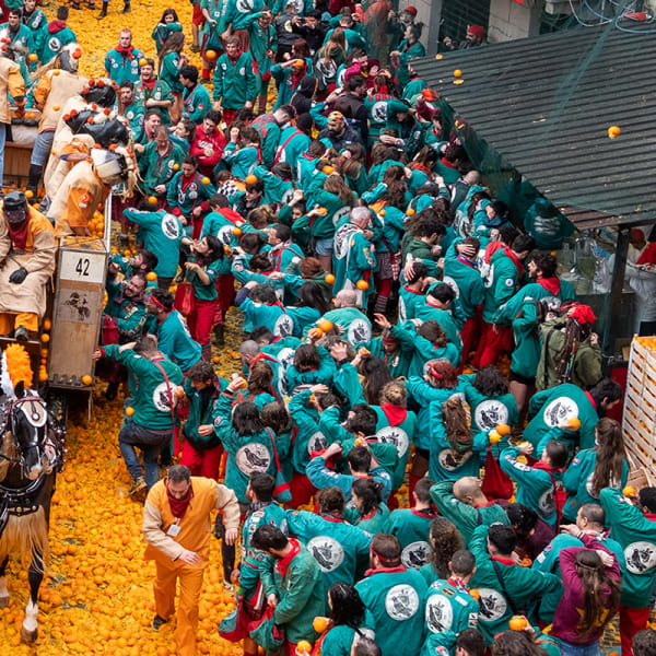 Crowd throwing oranges.