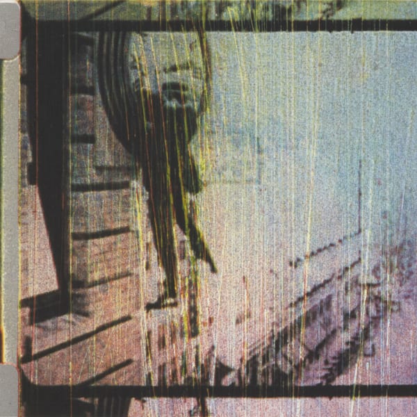 Blurred white and grey image with the outline of a dark clock on the left 
