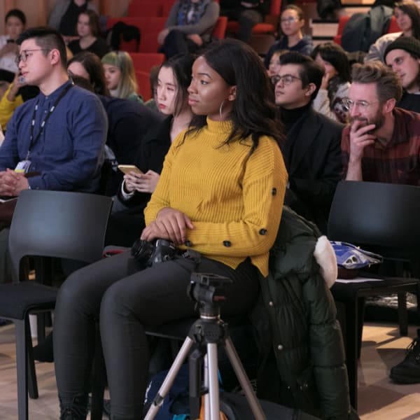 a group of people sitting on chairs listening to a seminar