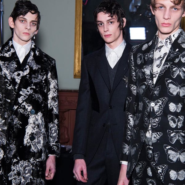 Five dark-haired male models in luxury suits.