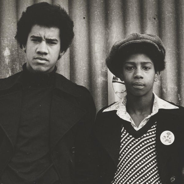 Three boys in descending height order, centre one with cloth cap