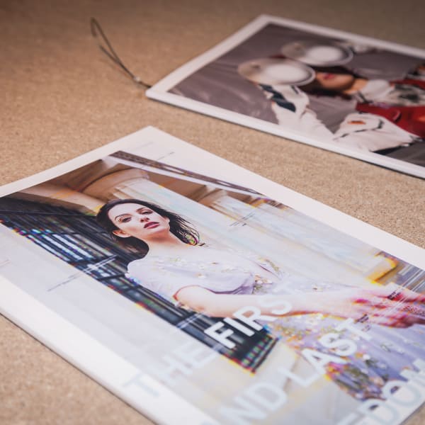 Fashion magazines attached to a cork board.