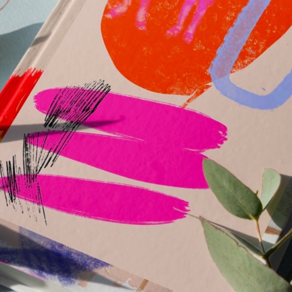Publication with pink and orange cover, with plant.
