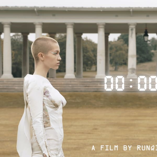Still from film of two females, one real and one robot, looking at each other.