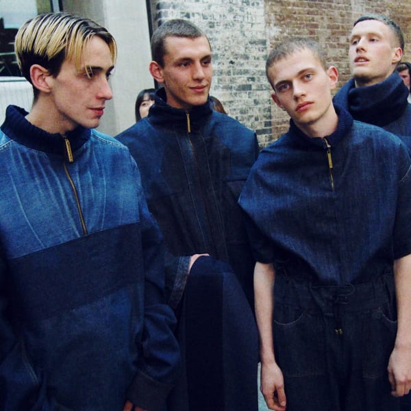 Five men wearing denim zip through blue garments