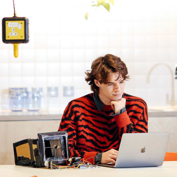 Student sat at a table working on their computer