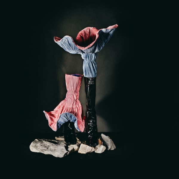 Embellished, colourful boots on a black background.