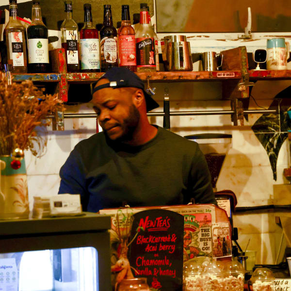 Daniel Imode behind the counter in a cafe.