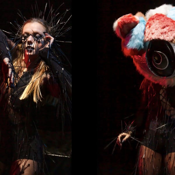 Two female models dressed in gothic black, one with a colourful teddy bear's head.